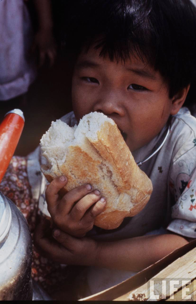 Chú bé gặm chiếc bánh mì to oành, Sài Gòn 1968. Ảnh: Larry Burrows/ Life.