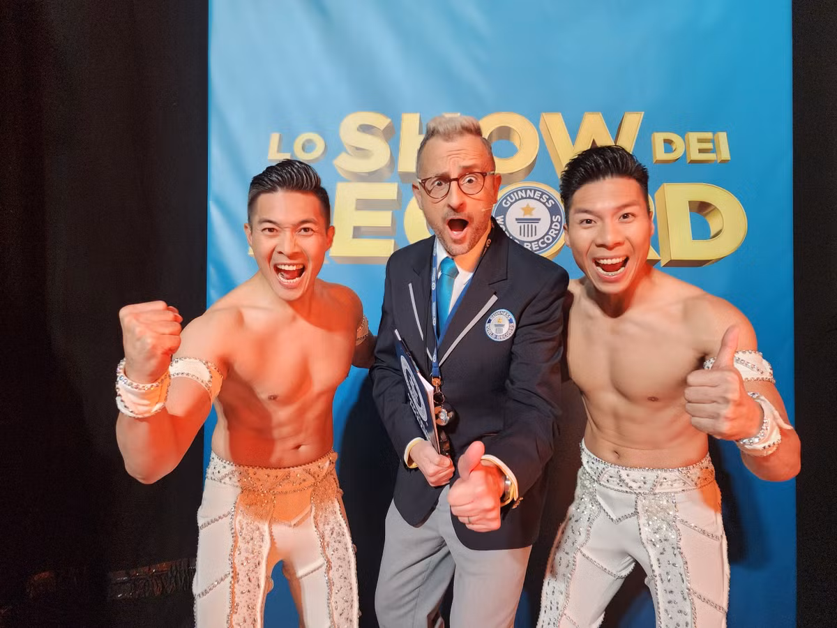 Quốc Cơ, Quốc Nghiệp chụp ảnh cùng đại diện của Tổ chức kỷ lục Guinness ở Italy. Sau thành công của chồng, trên trang cá nhân, O Sen Ngọc Mai chia sẻ: "Ôi, đã bình an".