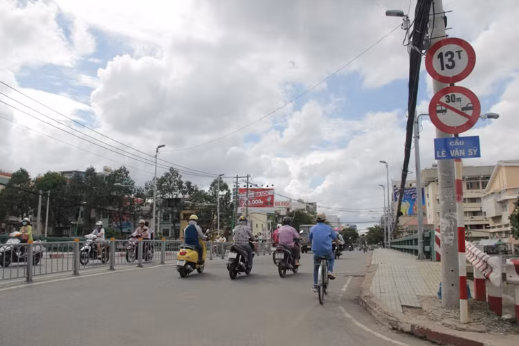 Ông Vương Hồng Thanh, Phó giám đốc BQL Đầu tư XDCT nâng cấp ĐTTPHCM cho biết: Toàn bộ các cây cầu sẽ phải hoàn thành vào 9/2014 (sau từ 8 đến 10 tháng thi công), nếu không Ngân hàng thế giới sẽ cắt nguồn vay vốn. Vì vậy kể từ ngày 20/10, 4 cây cầu nói trên sẽ được "đóng cửa" và phương tiện lưu thông qua cầu tạm đã được xây dựng cạnh bên. Ảnh: Cầu Lê Văn Sĩ (quận 3) được xây dựng từ trước năm 1975 và là một trong những cây cầu huyết mạch trong nội thành TPHCM.