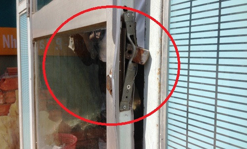 Cánh cửa ra vào buồng ATM bị trộm dùng cây sắt cạy phá để đột nhập.