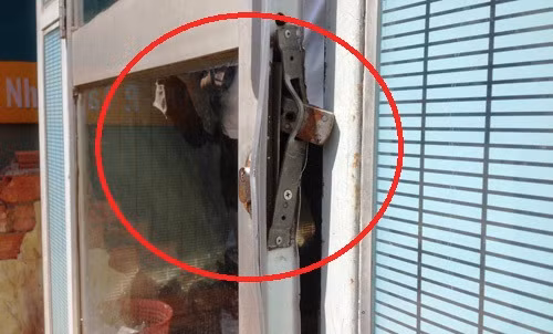 Cánh cửa ra vào buồng ATM bị trộm dùng cây sắt cạy phá để đột nhập.