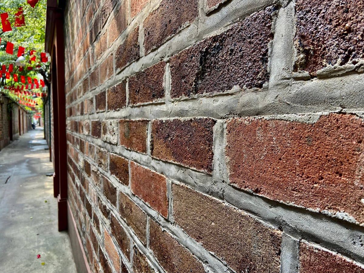 Tường được làm bằng gạch đỏ để trần tạo nên nét cổ kính, mộc mạc cho con ngõ.