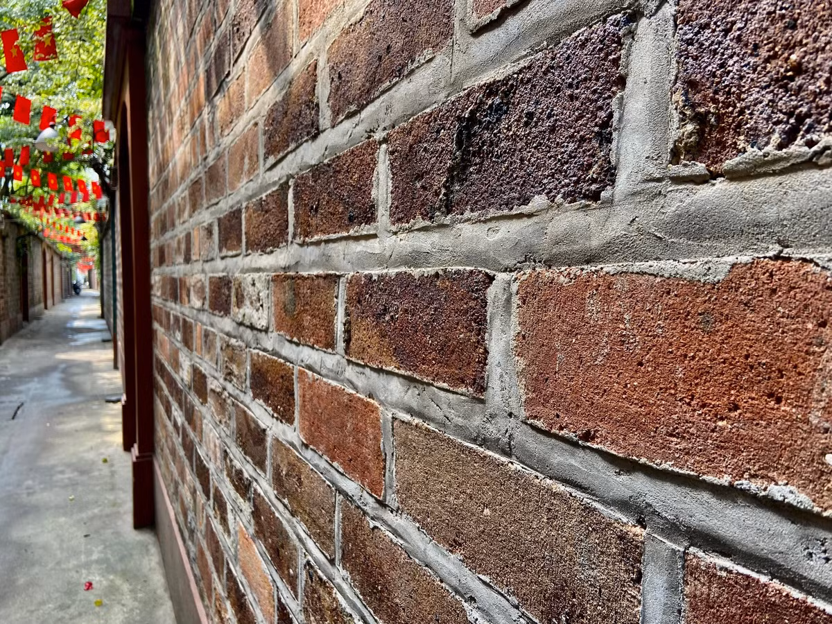 Tường được làm bằng gạch đỏ để trần tạo nên nét cổ kính, mộc mạc cho con ngõ.