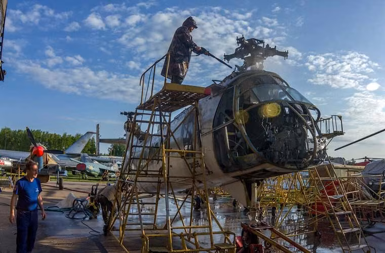 Các tình nguyện viên đang sửa chữa phần thân trực thăng 2 chong chóng không đồng trục Vertol 44C.