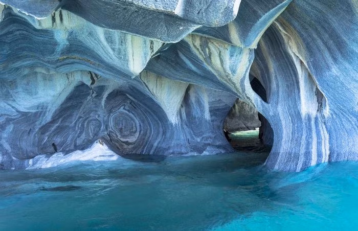Hang đá cẩm thạch, Chile: Nhiều du khách khi khám phá mạng lưới hang động nằm dưới hồ General Carrera, Chile, đã đánh giá đây là nơi "đẹp nhất thế giới". Thành hang được tạo ra từ khoáng chất canxi cacbonat, khi thủy triều rút bạn mới có thể khám phá các lối thông bên trong. Năm 1994, hang động được công nhận là Di tích quốc gia của Chile.