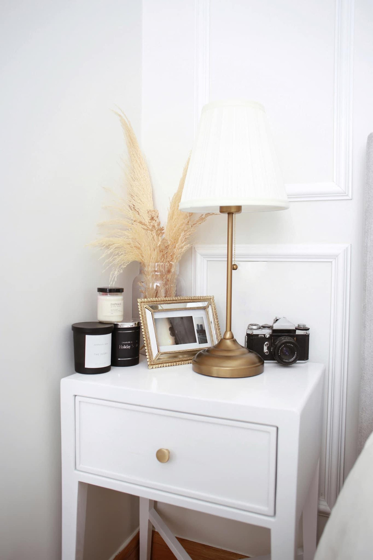 ủ đầu giường cũng theo một tông trắng basic. Thảo Nhi cho thấy phong cách sống tinh tế khi trưng thêm cành lau khô, nến thơm để góc giường có thêm điểm nhấn thú vị.