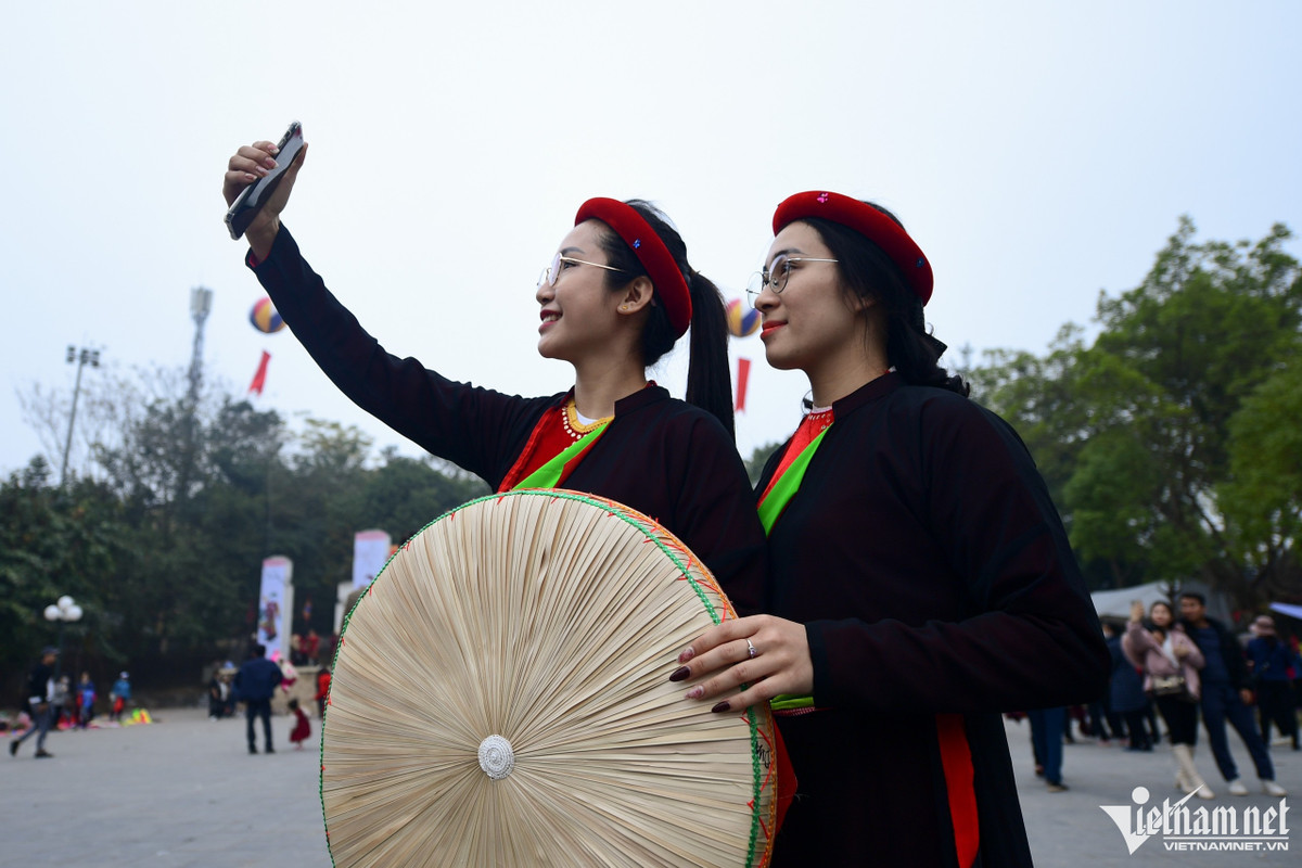 Miền (trái) và Hồng đi từ Bắc Giang đến hội Lim từ 15h. Hai bạn chọn chiều 12 tháng Giêng thay vì ngày chính hội vì muốn đi lại thoải mái, tránh sự đông đúc. "Năm nào chúng tôi cũng thuê trang phục này chỉ để chụp ảnh làm kỷ niệm. Mục đích là up lên mạng cho mọi người biết mình đi hội Lim", Miền nói.