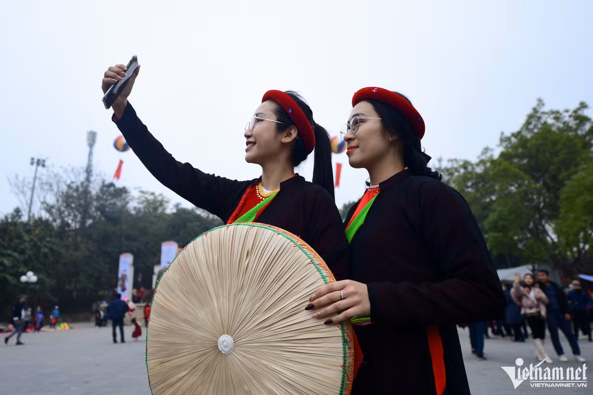 Miền (trái) và Hồng đi từ Bắc Giang đến hội Lim từ 15h. Hai bạn chọn chiều 12 tháng Giêng thay vì ngày chính hội vì muốn đi lại thoải mái, tránh sự đông đúc. "Năm nào chúng tôi cũng thuê trang phục này chỉ để chụp ảnh làm kỷ niệm. Mục đích là up lên mạng cho mọi người biết mình đi hội Lim", Miền nói.