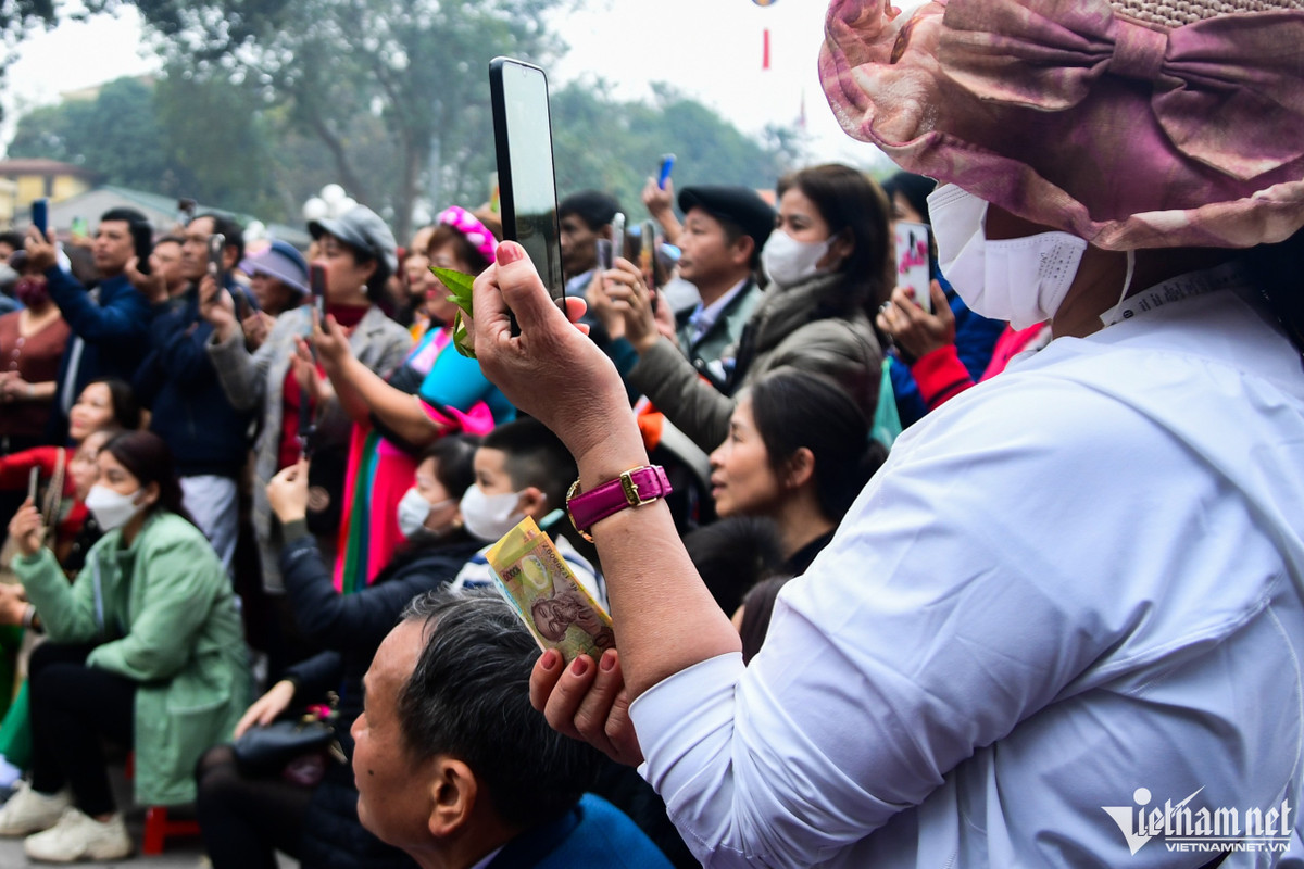 Một số du khách cầm sẵn tiền mệnh giá 10.000-20.000 đồng để chuẩn bị lì xì, có người hào phóng cho hẳn tờ 100.000 đồng.