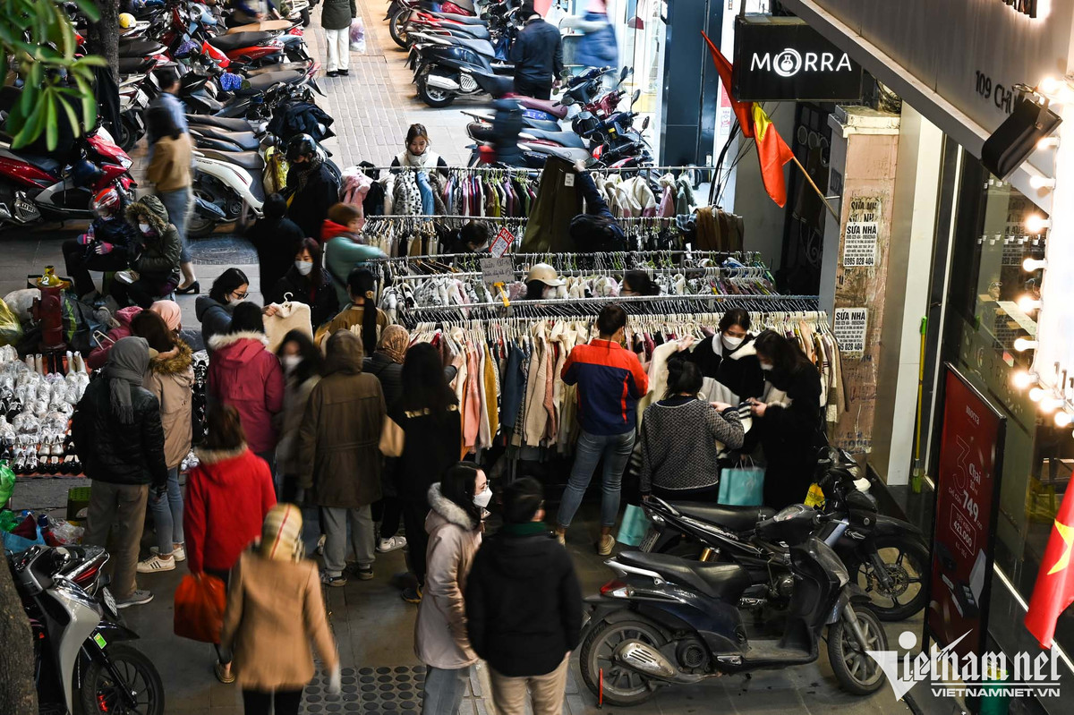 Trông con trên vỉa hè chờ vợ chen chân mua quần áo giảm giá Trong con tren via he cho vo chen chan mua quan ao giam gia