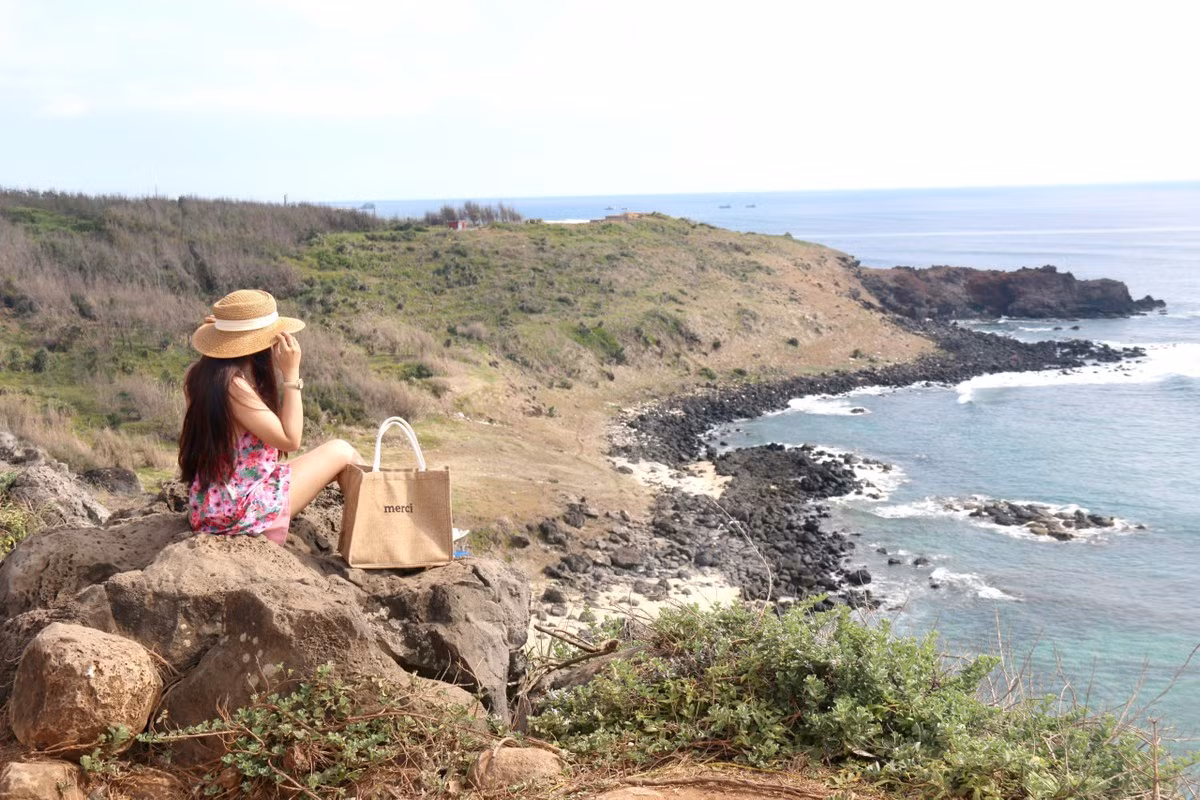 Du khách "sống ảo" bên bờ biển ở đảo Phú Quý. Không chỉ vậy, nơi đây còn có di tích lịch sử quốc gia chùa Linh Quang – ngôi chùa cổ nổi tiếng đậm nét tâm linh của người dân đảo, chùa Linh Sơn nằm trên núi Cao Cát, vạn An Thạnh, miếu Bà Chúa Bàn Tranh… Đặc biệt, hệ sinh thái trên đảo khá đa dạng, môi trường xanh, sạch cùng nhiều bãi cát vàng trải dài ôm trọn đảo. Ảnh: VĂN THANH.