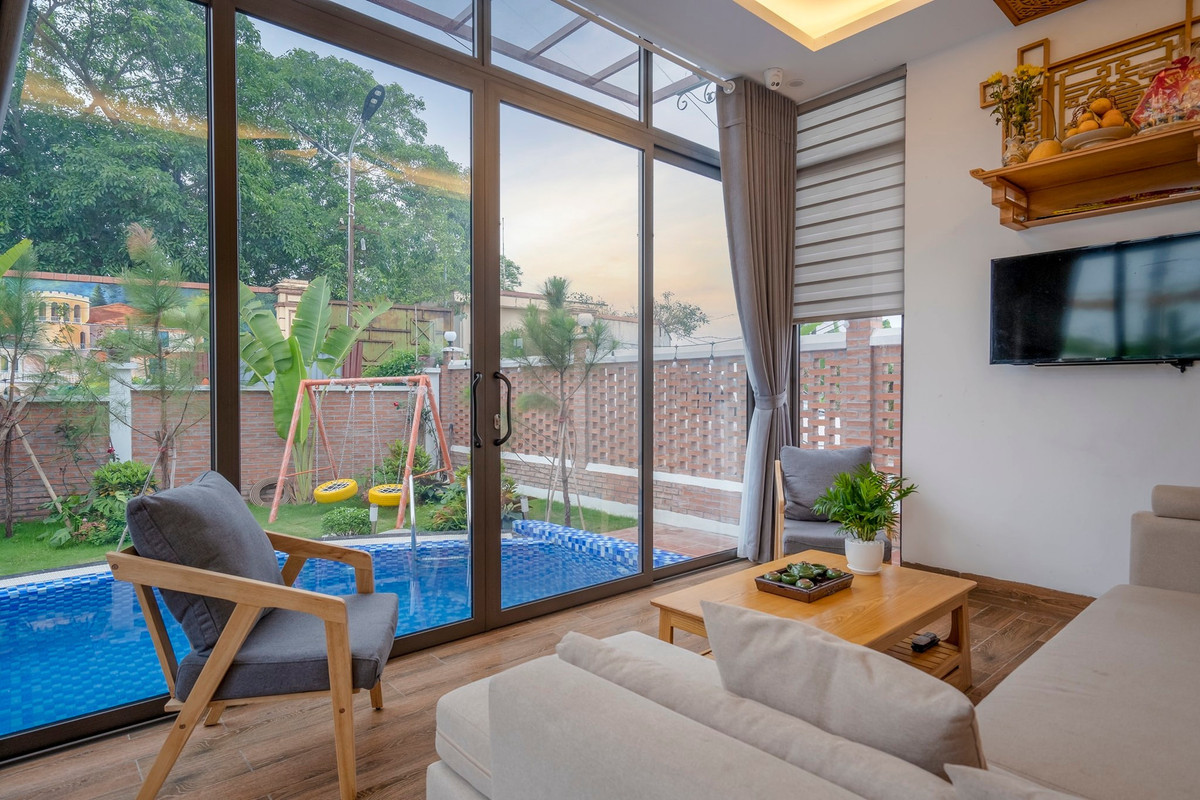 Phòng khách, bếp và bàn ăn nhìn ra bể bơi, nơi chị Hiên Phạm có thẻ vừa nấu ăn vừa quan sát các con đang nô đùa ngoài bể vào ngày hè.