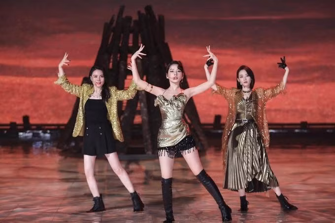 Bộ váy tông vàng đồng ở đêm công diễn 2 cũng là sản phẩm được biến tấu bởi Hoàng Ku. Phiên bản gốc dài đến đầu gối Chi Pu. Stylist đã cuốn phần tà tạo thành các nếp gấp và kết hợp cùng chiếc quần ngắn tua rua. Vì váy của ê-kíp chuẩn bị, anh không được cắt (Ảnh: Mango TV).