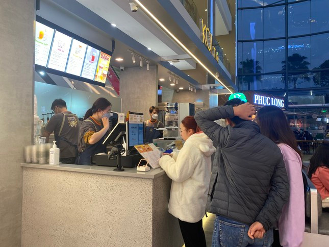 Quầy trà sữa luôn có khách xếp hàng chờ đặt đồ, nhận đồ. Ngoài ra, lượng khách đặt món qua các ứng dụng giao đồ ăn trực tuyến cũng rất lớn. Nhân viên cửa hàng không lúc nào ngơi tay