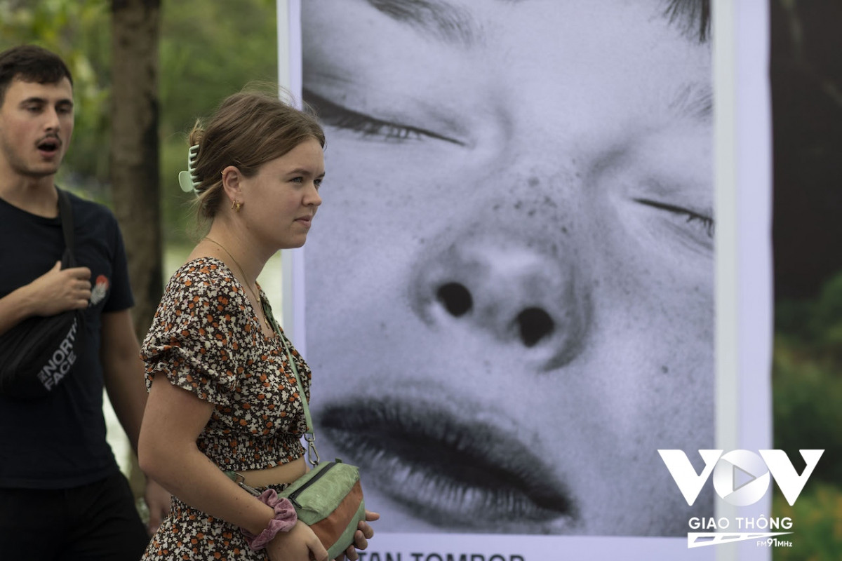 Du khách đến xem một triển lãm ảnh được tổ chức ngoài trời, trên phố đi bộ hồ Hoàn Kiếm.