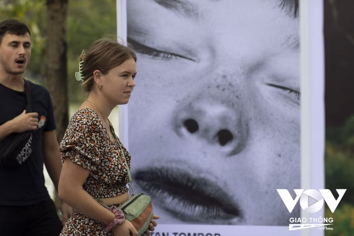 Du khách đến xem một triển lãm ảnh được tổ chức ngoài trời, trên phố đi bộ hồ Hoàn Kiếm.