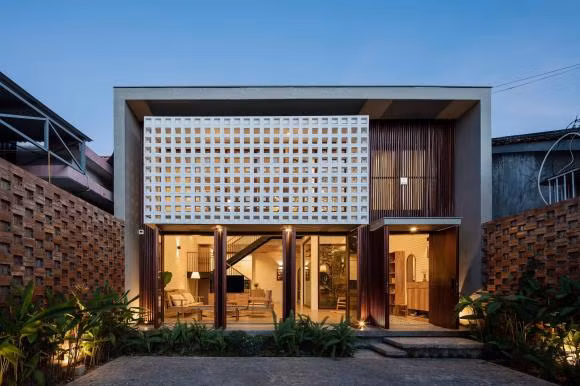 Trước ngôi nhà là một khoảng sân vườn với đủ loại cây cảnh, nhằm giảm bớt tác động của tiếng ồn và khói bụi. Hình khối và cấu trúc mặt đứng 2 lớp, giúp không gian ở tránh được bức xạ trực tiếp từ hướng tây nhưng vẫn tràn ngập ánh sáng và thông gió tự nhiên.