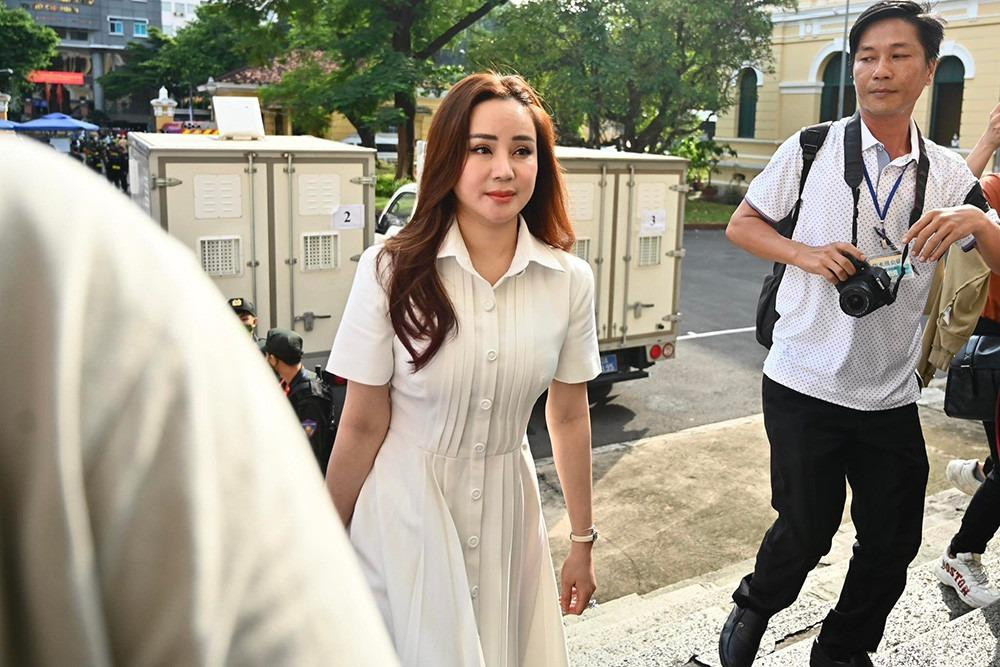 a sĩ Vy Oanh tới phiên tòa ngay sau đó cùng luật sư. Cô diện váy trắng, trang điểm nhẹ nhàng.