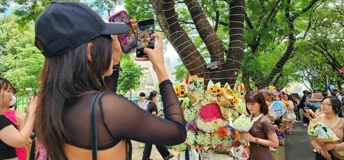 Cô gái chụp hình cho người thân trên con đường phố Phan Đình Giót Ban Mê giữa trưa mà dòng người vẫn đông tấp nập (ảnh: Đại Đậu).