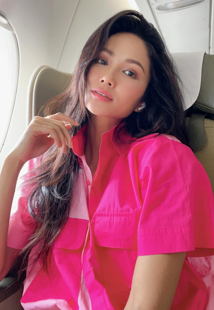 H'Hen Niê diện áo hồng khi lên máy bay, được tiếp viên trưởng nhận xét 'hoa hậu làm rực cả một khoang'.