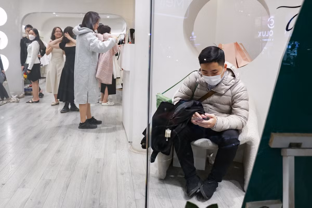 Một số khác vào bên trong cửa hàng ngồi đợi trong khu vực chờ. Họ thường cầm túi xách, áo khoác giúp bạn gái, người thân mình thoải mái lựa đồ.