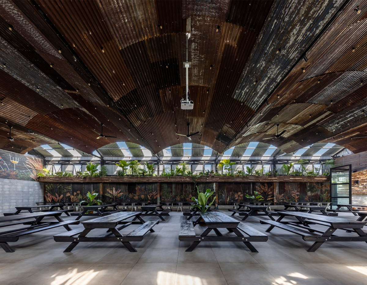 Khu vực ăn uống trong nhà được thiết kế với phần mái tôn cách nhiệt kết hợp hệ trần trang trí cũ kĩ, hệ thống phun sương ẩn nấp khéo léo trên mái và mảng cây cối được treo lên để giảm nóng đồng thời tăng cảm giác mới mẻ cho thực khách để tạo điểm thu hút riêng biệt cho khu vực này.