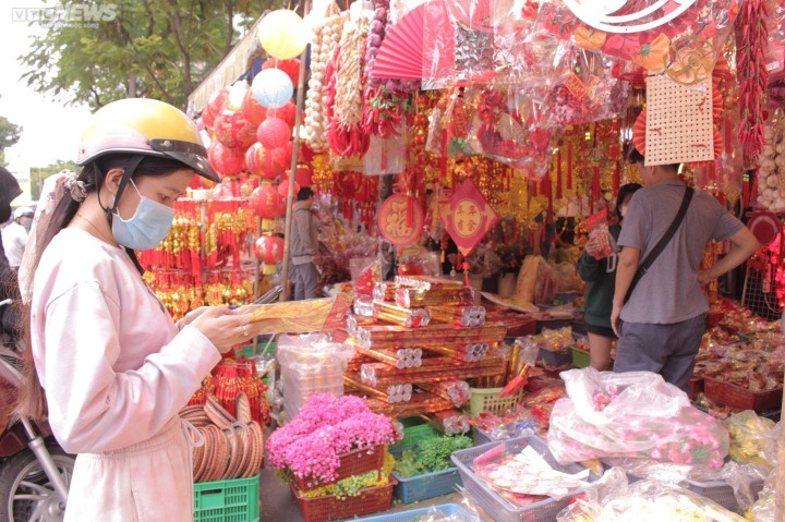 Bên trong một cửa hàng bày bán đủ loại đồ trang trí Tết với màu sắc đỏ thắm như đồng tiền vàng, miếng vàng, chữ chúc Tết được làm bằng vải nhung đỏ, họa tiết vàng với nhiều kiểu dáng cũng như kích cỡ lớn, nhỏ...