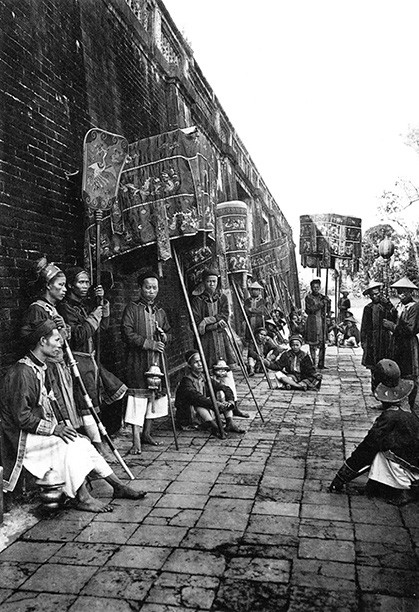 br/> Pierre Dieulefils (1862 - 1937) đến từ vùng Bretagne - Pháp. Ông gia nhập quân đội năm 1883, sang Đông Dương lần đầu năm 1885. Hai năm sau, ông giải ngũ rồi trở về Pháp. Năm 1888, ông quay lại miền Bắc Việt Nam, rẽ sang làm nghệ sĩ nhiếp ảnh và xuất bản bưu ảnh chuyên nghiệp. Ảnh: Đội thị vệ trong cung với lọng, quạt...