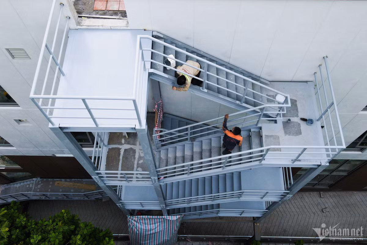 Một tòa nhà khác cao 3 tầng ngay cạnh đó cũng đang trong quá trình hoàn thiện lắp đặt cầu thang thoát hiểm bên ngoài. Cầu thang này rộng, bắc từ sân thượng xuống tới mặt đất.