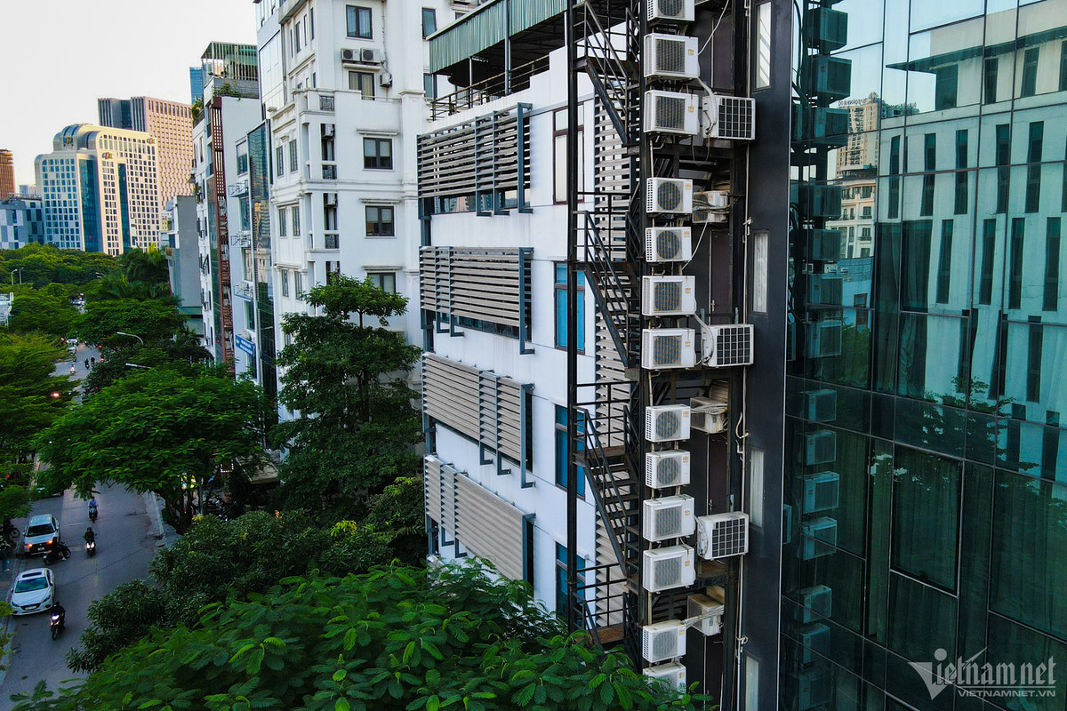 Một tòa nhà cao tầng được thiết kế cửa kính kín có khu vực thoát hiểm riêng. Cục nóng điều hòa được treo lên khu vực thang để đảm bảo tính thẩm mỹ cho tòa văn phòng.