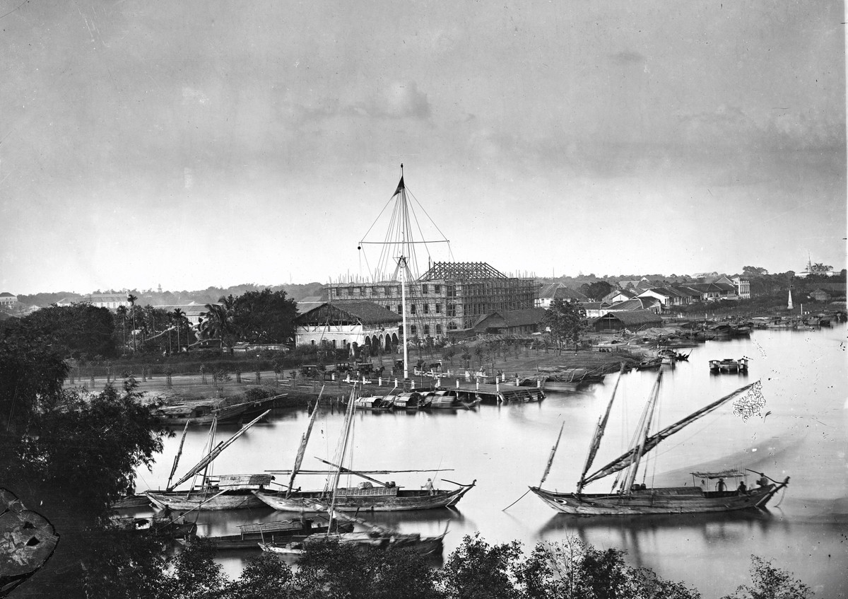 John Thomson (1837-1921) là nhà nhiếp ảnh người Scotland. Ông ghé Nam Kỳ năm 1867. Trong vài tháng ở Sài Gòn ông đã chụp các bức ảnh, nay vẫn còn. Ảnh Sài Gòn năm 1867. Ảnh chụp từ địa điểm bến Nhà Rồng hiện nay, cho thấy cột cờ Thủ Ngữ với các người lính chung quanh, đằng sau là nhà ông Vương Thái đang xây.