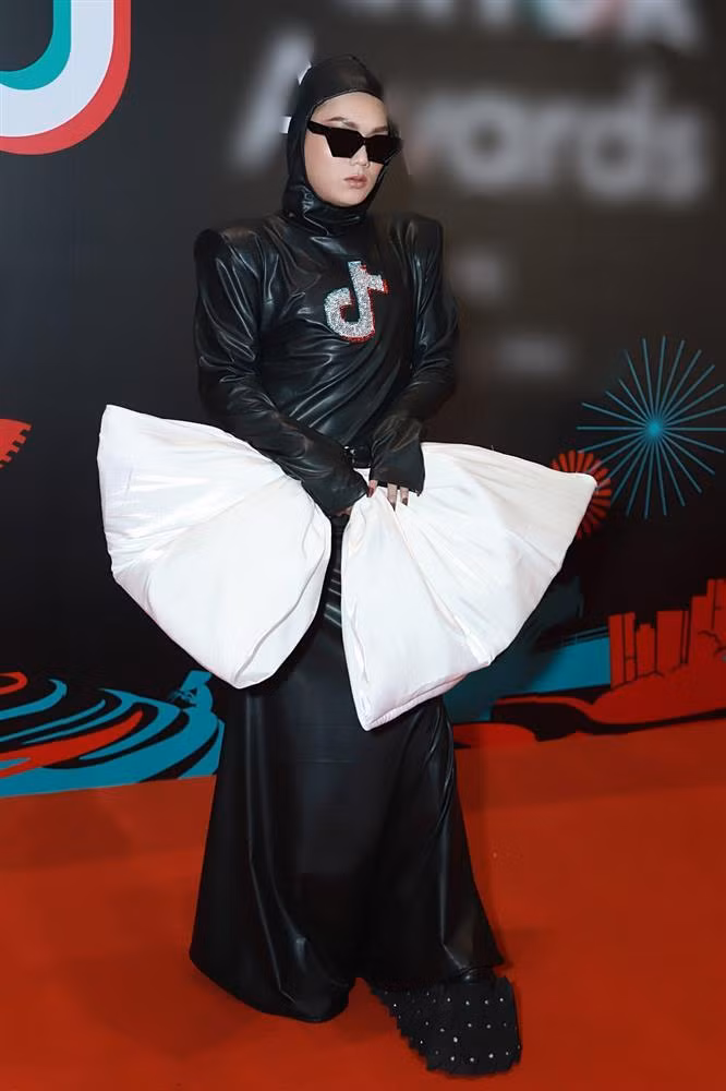 Xuất hiện ở một sự kiện, Tiktoker Phạm Thoại mặc bộ váy da trùm kín như người ngoài hành tinh kết hợp với một chiếc nơ to tướng màu trắng nhăn nhúm, lạc quẻ.