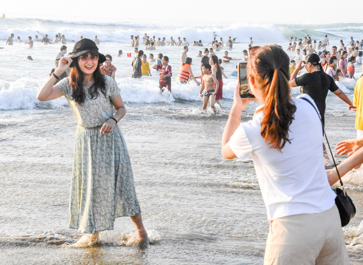 Nhiều du khách đến bãi biển nơi đây check-in lưu lại những khoảnh khắc đẹp trong buổi bình minh. "Những ngày qua, tiết trời miền trung nắng nóng, chúng tôi đưa các con đến TP Đà Nẵng du lịch, tắm biển vào buổi sáng sớm nơi đây thật tuyệt vời", chị Ý Nhi, nữ du khách đến từ Hà Nội, chia sẻ.