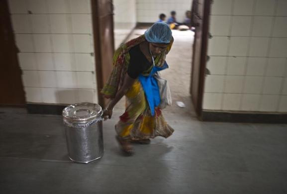 Nhân viên tình nguyện kéo hộp thức ăn miễn phí phục vụ cho các em học sinh tại trường tiểu học.