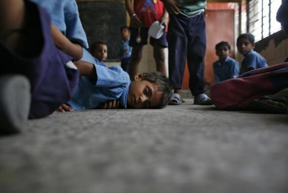 Một bé trai ngủ tại lớp trước khi đến giờ ăn trưa.