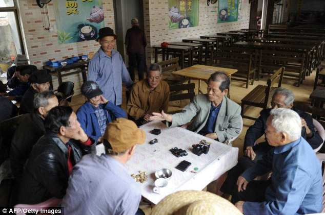 Các cụ ông quây quần chơi mạt chược trong phòng trà.