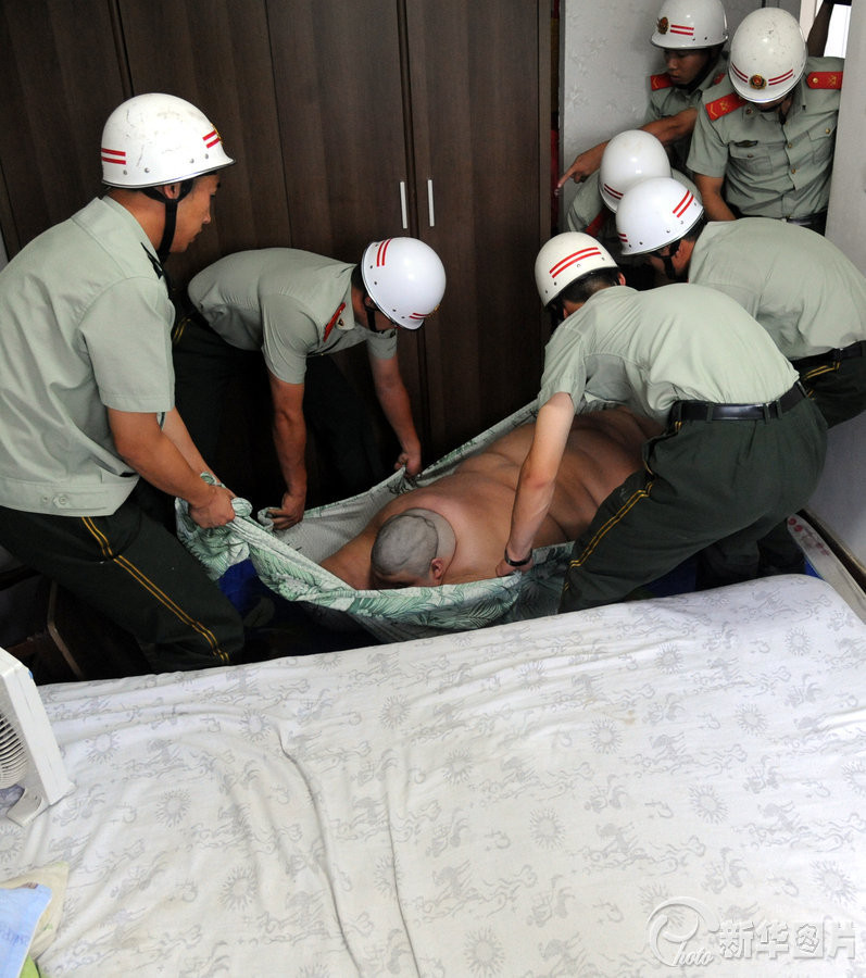 Chàng trai này được di chuyển bằng cách gói gọn trong tấm ga trải giường và được nhóm cứu hộ khiêng đi.