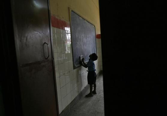 Một cậu bé học sinh tiểu học đang chép lại bài trên bảng trước giờ ăn trưa.