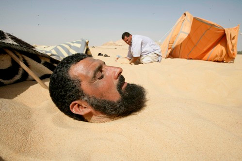 Mohmmed Emad, 41 tuổi chôn mình trong lớp cát tại khu vực núi El Dakrror ở Siwa Oasis, Ai Cập.