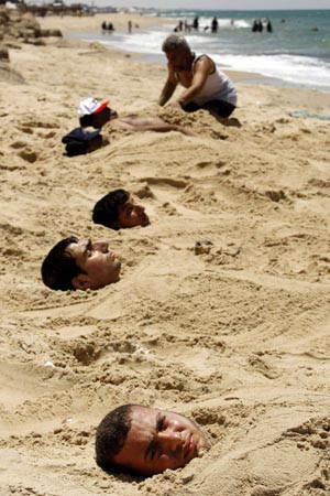 Những bệnh nhân người Palestinin này tin rằng chôn mình dưới cát nóng có thể chữa khỏi bệnh về da.