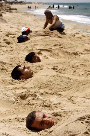 Những bệnh nhân người Palestinin này tin rằng chôn mình dưới cát nóng có thể chữa khỏi bệnh về da.