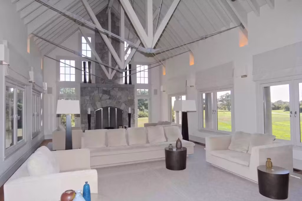 Bên trong có một phòng tiếp khách cỡ lớn, kết hợp cấu trúc trần cao và lò sưởi bằng đá. Ảnh: Realtor.