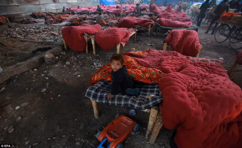 Những ngày đầu năm mới, nhiệt độ ở miền bắc Ấn Độ giảm mạnh xuống mức -12 độ C vào ban đêm. Còn nhiệt độ ở thủ đô Delhi giảm xuống còn 2 đến 4 độ C – mức thấp kỷ lục tại thời điểm này trong suốt 17 năm qua. Trong ảnh, một em bé qua đêm trên chiếc phản gỗ ngoài trời trong cái lạnh cắt da cắt thịt tại một khu vực tập trung người vô gia cư giữa lòng thủ đô Delhi.