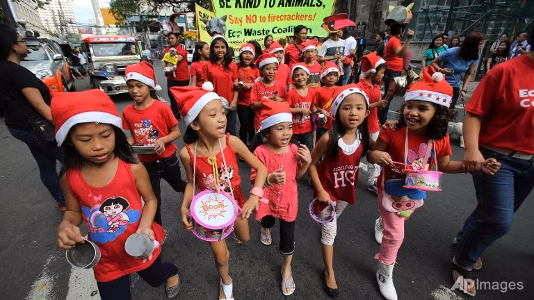 Trẻ em ở Manila, Philippines hân hoan chào năm mới với những món đồ chơi như trống và xúc xắc.