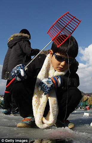 Cậu bé tập trung và kiên nhẫn ngồi đợi cá cắn câu.