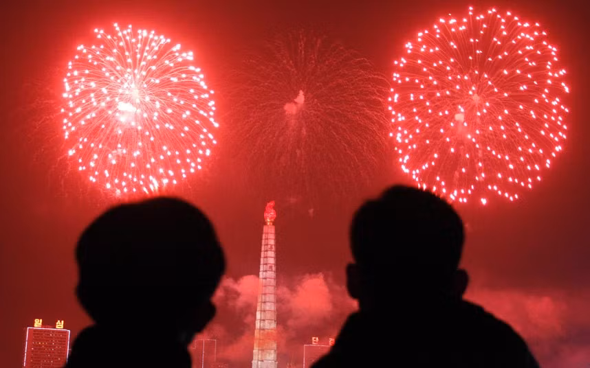 Pháo hoa rực rỡ thắp sáng bầu trời phía trên tháp Juche và sông Taedong ở Bình Nhưỡng, Triều Tiên trong đêm giao thừa.