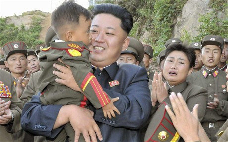 Nhà lãnh đạo Triều Tiên Kim Jong-un âu yếm bế một bé trai trên tay.