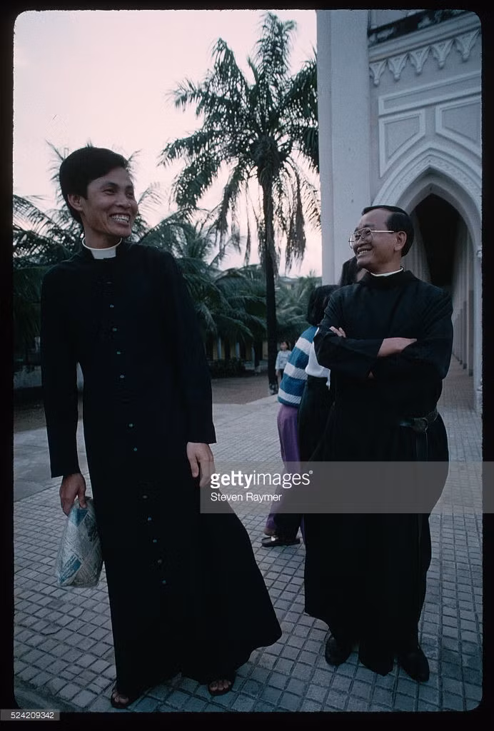 Hai linh mục nói chuyện với nhau trước giờ thánh lễ Chủ nhật ở nhà thờ Con gà Đà Nẵng.