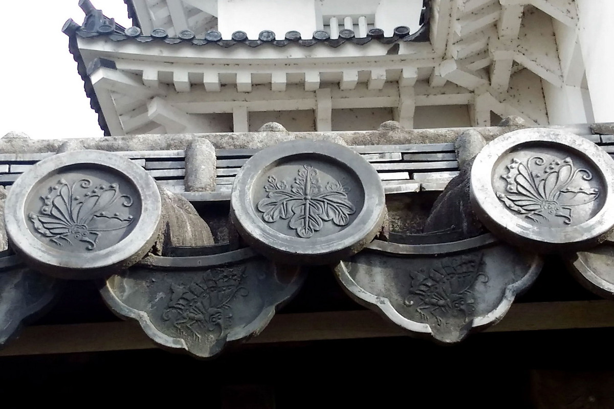 Nét đẹp kiến trúc của lâu đài Himeji, ngoài kết cấu gỗ, còn thể hiện ở các tầng mái ngói ống, đầu mái cũng như diềm mái được trang trí hoa văn hoa lá thanh thoát, được tạo ra từ cách dập nổi hoa văn từ trước khi nung. Ảnh: DriveJapan.