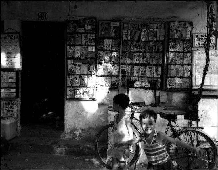 Những đứa trẻ chơi đùa trước một hiệu sách cũ.